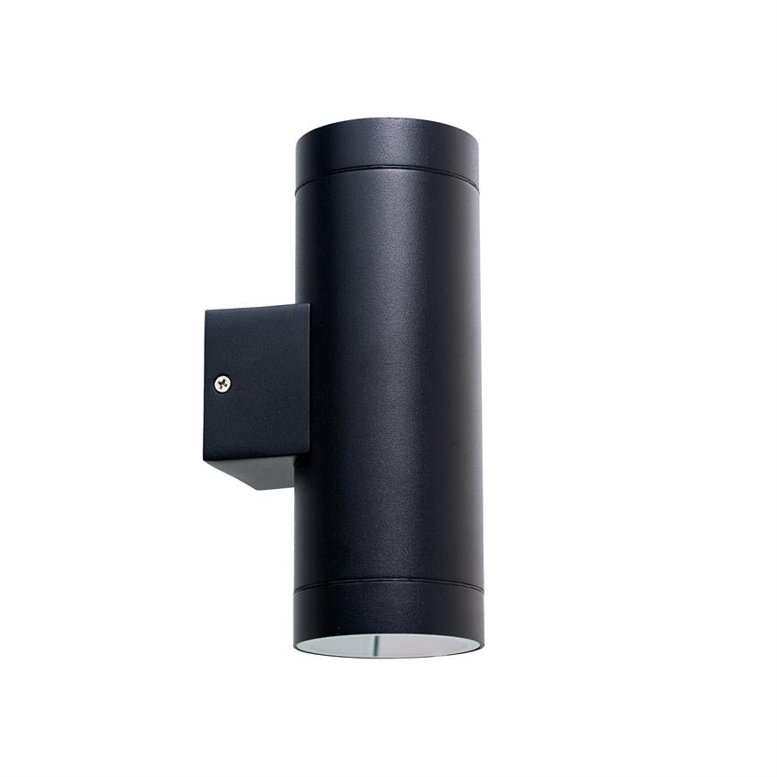 Cylindrisk sort væglampe (objekt), monteret på et lille firkantet beslag og peger nedad med åben bund (handling), mod en neutral hvid baggrund (kontekst).