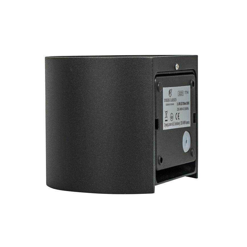 Sort halvrund væglampe i profil, med bagpanel synligt og åben, viser monteringsåbning og etiket mod en hvid studiobaggrund.
 
 Transkription af synlig tekst (delvist læselig): "220-240 V ~ 50/60 Hz", "CE", overstreget skraldespandsymbol, "0021", "1114". Resten af teksten er for lille til at tyde.