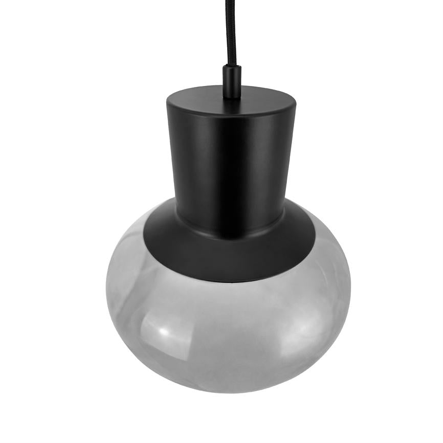 En sort pendelampe hænger, dens matte sorte fatning forener en stor rund, let røgfarvet glaskuppel; enkel, moderne stil mod en ren hvid baggrund.