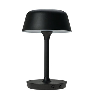 Sort bordlampe med rund skærm på slank midterstang; står på en flad, rund fod, funktionelt borddesign i moderne, minimalistisk stil foran en hvid, ensartet baggrund.