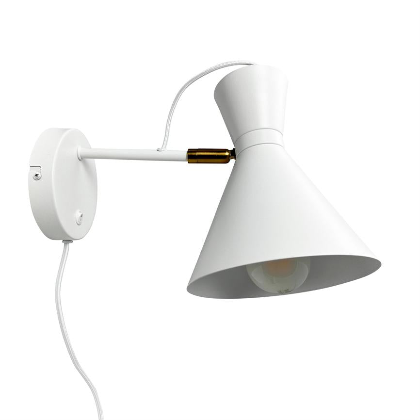 Væglampe med kegleformet skærm, peger nedad; fastgjort på en lige arm fra en rund vægplade. Hvid metal med messingdetalje, synlig glødepære og hvid stofledning på hvid baggrund.