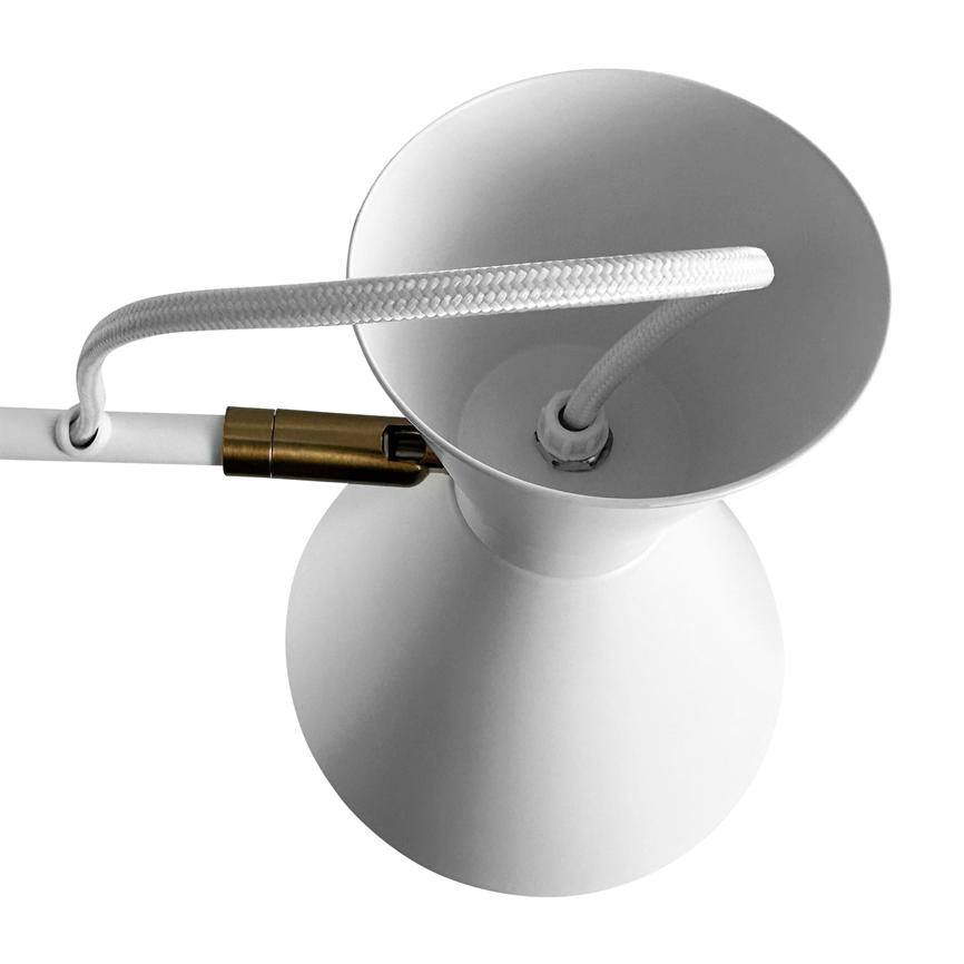 Hvid lampeskærm (objekt) med snoet hvid ledning ført gennem toppen (handling), forbundet til en lille messingkontakt; enkel, isoleret mod en ensartet hvid baggrund (kontekst).