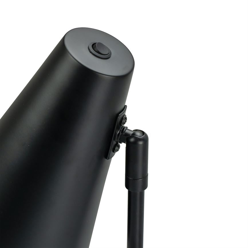 Sort skrivebordslampe vinkler sit koniske lampehoved; et metalled forbinder skærm og stang mod en hvid baggrund.