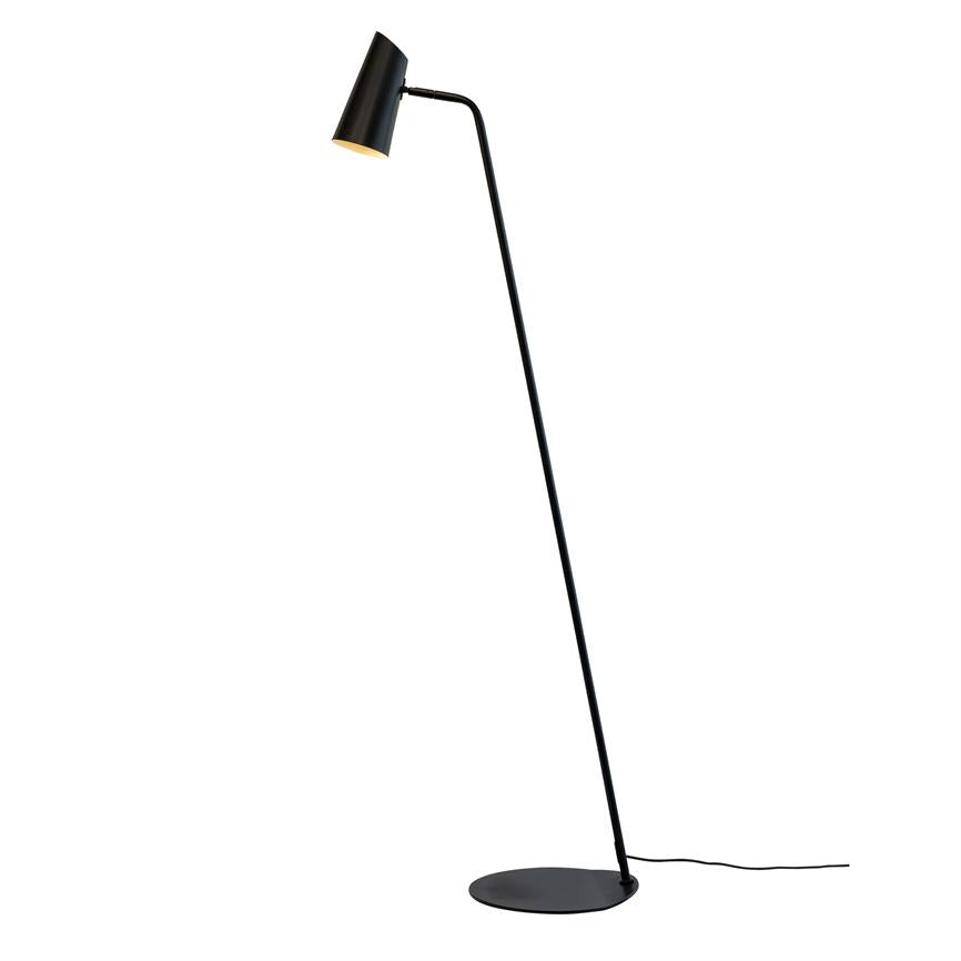 Sort gulvlampe med slank, buet arm, skærmen vippet nedad; rund metalfod og synlig sort ledning på neutral hvid baggrund.