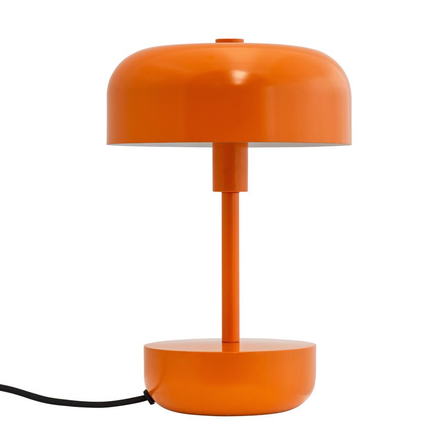 En orange metal bordlampe står på hvid baggrund: rund kuppel, smal søjle, cylindrisk base og rund fod, med sort strømledning, der løber ud mod venstre.