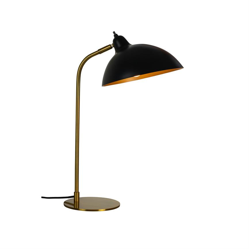 En skrivebordslampe med sort kuppelskærm og gyldent indre, vippet nedad og kaster lys; slankt gyldent stativ og fladt rundt fodstykke på hvid, neutral baggrund.