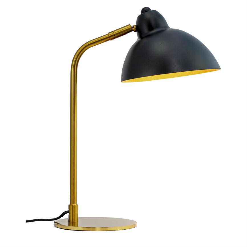 En bordlampe med sort kuppel-skærm og gylden arm står bøjet og retter lyset nedad mod bordet på en rund gylden base; sort ledning ligger mod hvid baggrund.