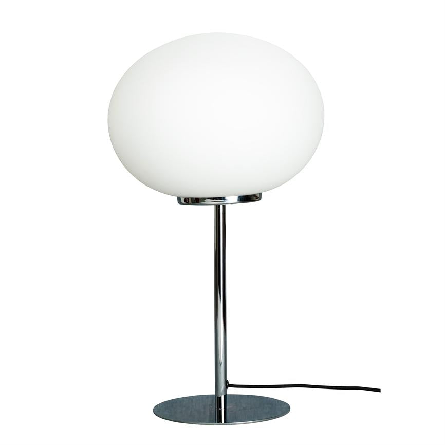 Bordlampe med stor hvid oval glas-skærm; hviler på en slank kromstang og rund kromfod, sort ledning ligger ved foden, mod en neutral hvid baggrund.