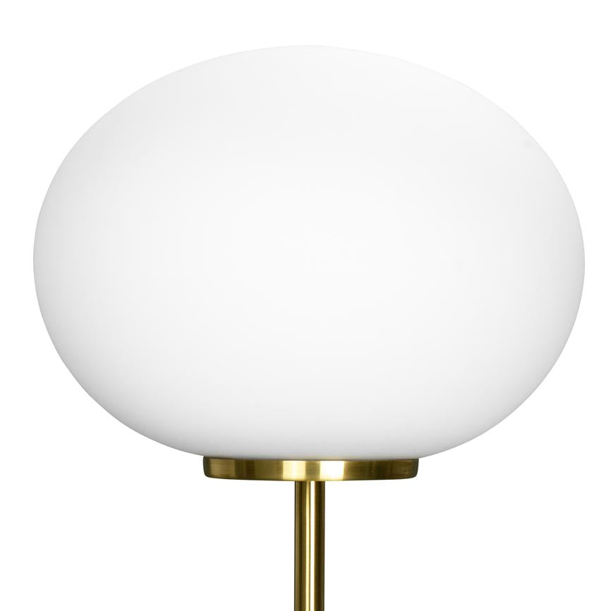 Rund, hvid lampekuppel hviler på en slank messingtstang med en kort messingring; enkel, moderne lampe mod ensartet hvid baggrund.