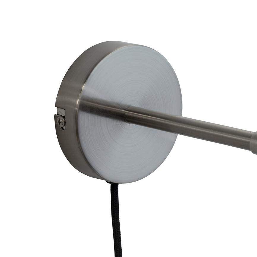 Rund børstet metalmontering holder en tynd, vandret metalstang; en sort stofledning hænger ned fra monteringen foran en neutral hvid baggrund.