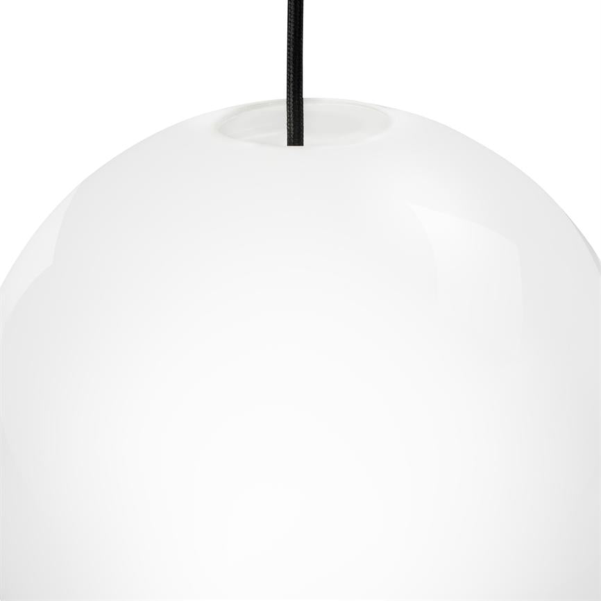 Hvid, blank kugleformet pendel hænger i en sort stofledning over en ensfarvet hvid baggrund i et minimalistisk, studiopræget miljø.