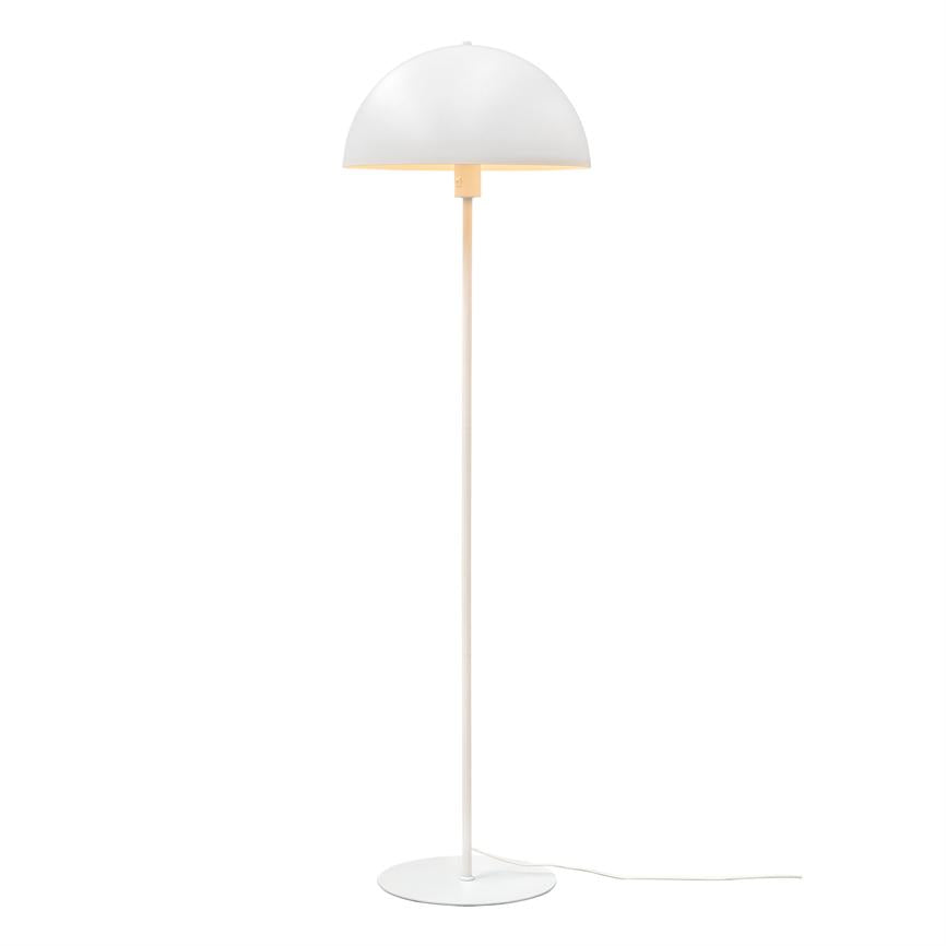 En hvid, halvkugleformet gulvlampe står på en slank stang og rund base; lampen kaster et blødt, varmt lys nedad og står frit mod en neutral, hvid baggrund.