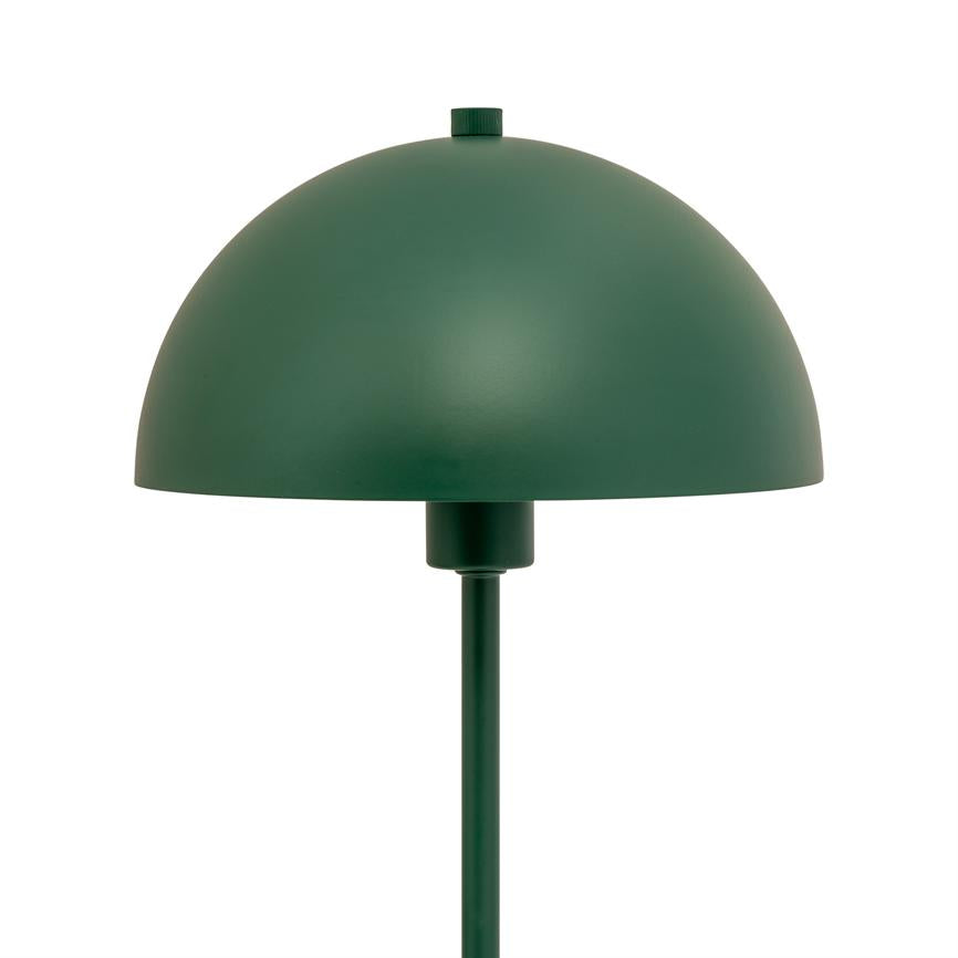 En grøn, halvkugleformet bordlampe hviler på et slankt skaft, placeret mod en neutral hvid studiobaggrund.