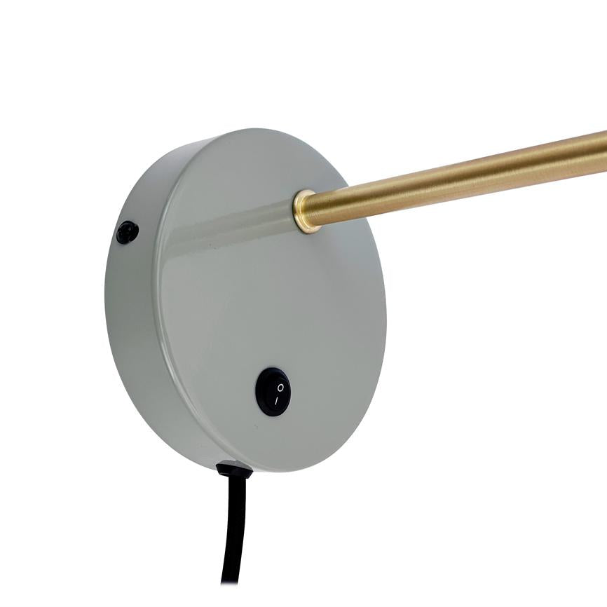Rund grå lampebase, der holder en slank messingstang; base har en sort tænd/sluk-knap mærket 'O' og 'I' og en sort ledning mod hvid baggrund.