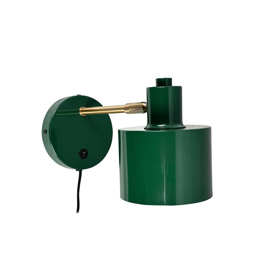 Væglampe: grøn metal lampeskærm monteret på en kort messingarm, fastgjort til en rund grøn vægbasis; sort ledning og afbryder hænger ned mod en neutral hvid baggrund.