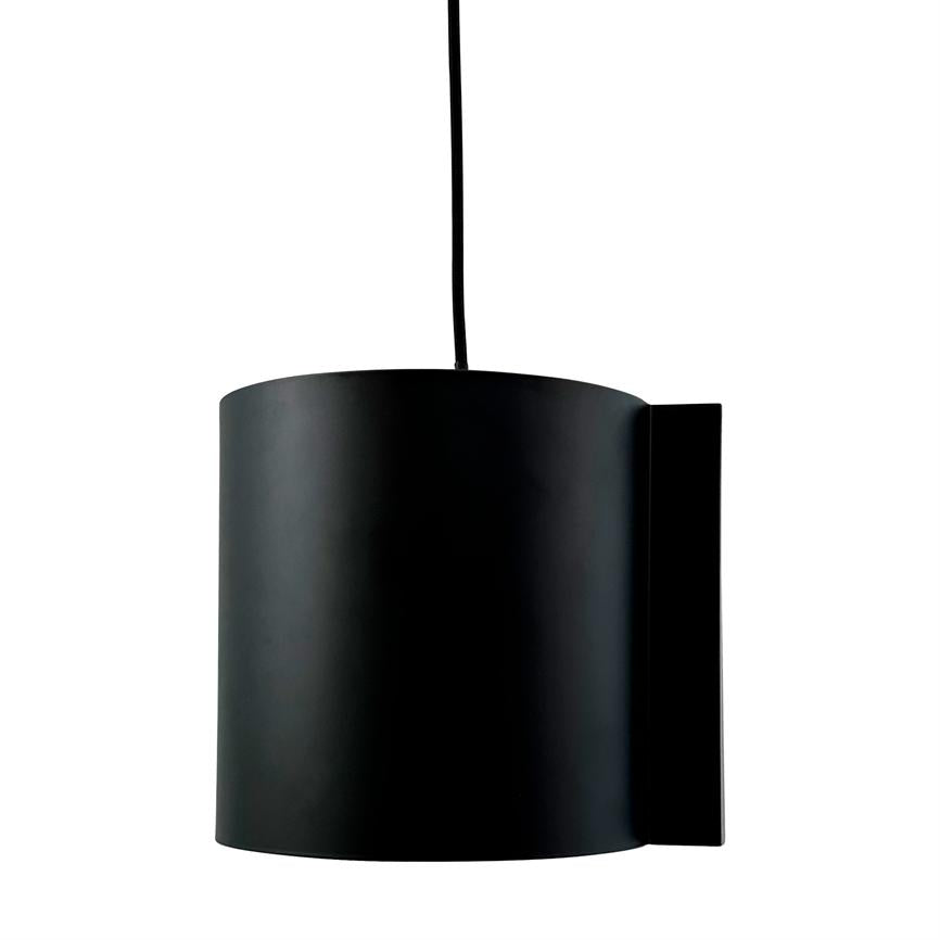 Sort cylindrisk hængelampe hænger i en tynd sort ledning, med en flad vægplade til højre, foran en neutral hvid baggrund.