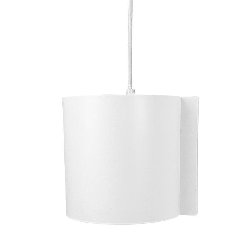 En cylindrisk hvid lampe hænger i en synlig ledning; den er monteret foran en rektangulær vægplade og ses mod en ensartet hvid baggrund i minimalistisk stil.