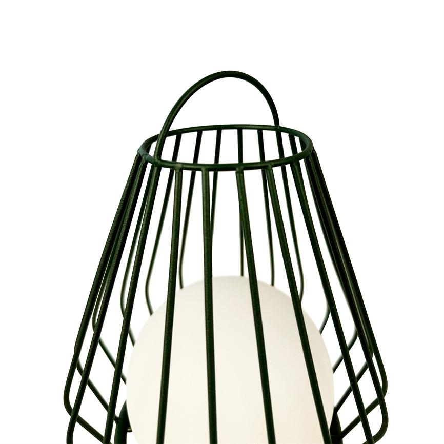 Sort metal trådkurv-lignende lampeskærm omslutter en hvid rund pære, med buet metalhåndtag øverst, placeret mod en ensartet hvid baggrund.