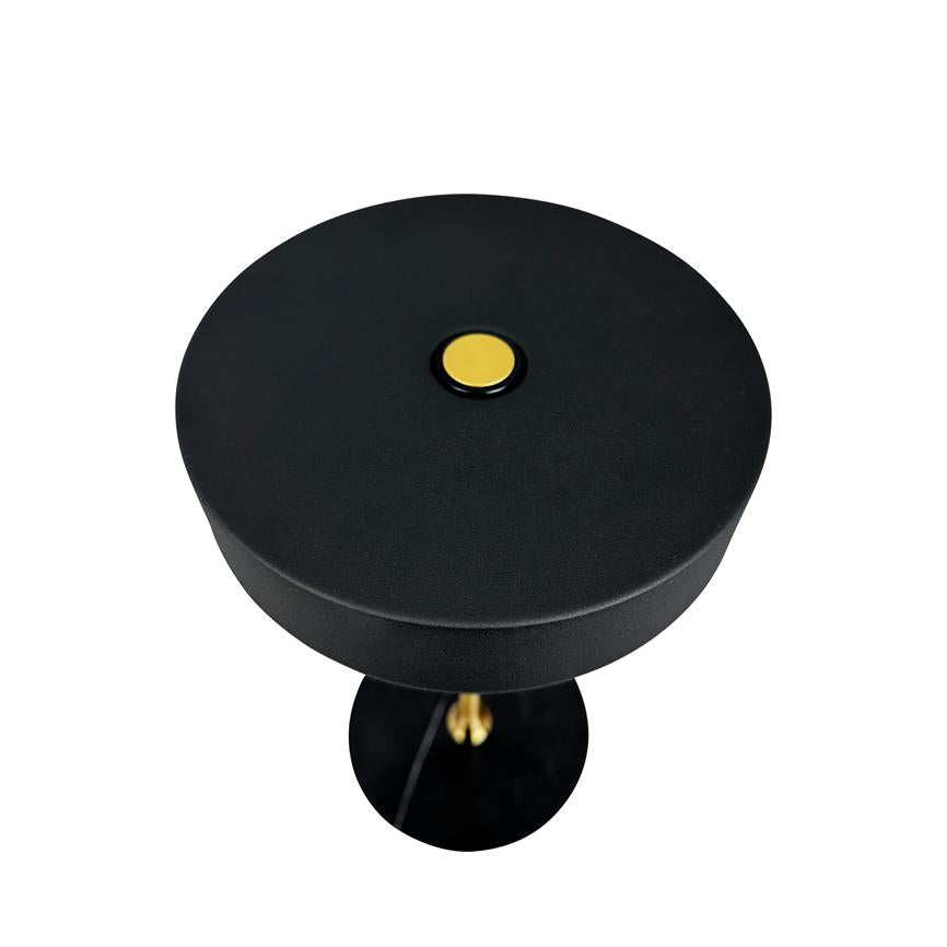 Sort, rund bordlampe har en gul trykknap på midten; den står på hvid baggrund set ovenfra, hvor topskiven og en del af standeren er synlige.