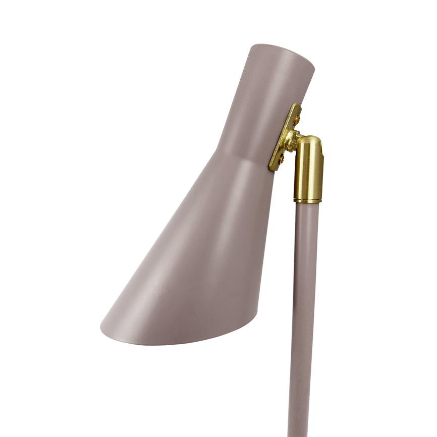 En støvet rosa lampehoved hælder nedad mod venstre; det er forbundet til en slank stok med en gylden messingled og vises isoleret mod en hvid baggrund.
