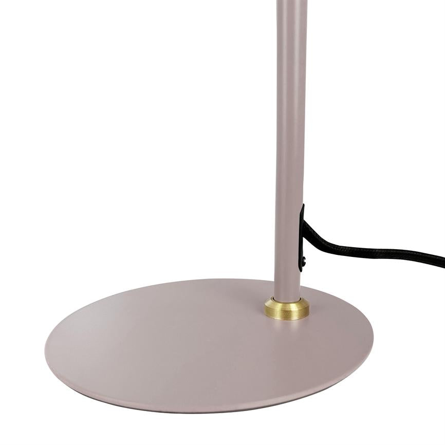 Rund lampefod står, en slank rosa metalstang er fastgjort med en lille gylden ring, og en sort stofbelagt ledning løber langs stammen mod højre på hvid baggrund.