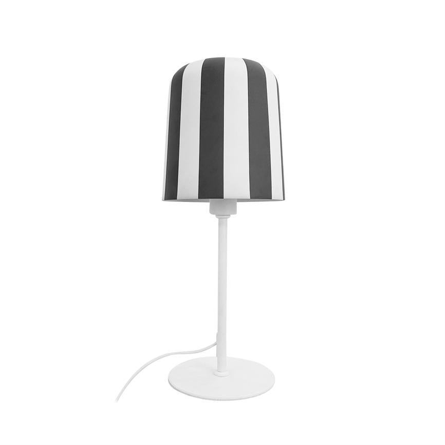 Bordlampe står på en rund hvid fod; lampskærmen har lodrette sorte og hvide striber; hvid stang og synlig hvid ledning mod en ensartet hvid baggrund.