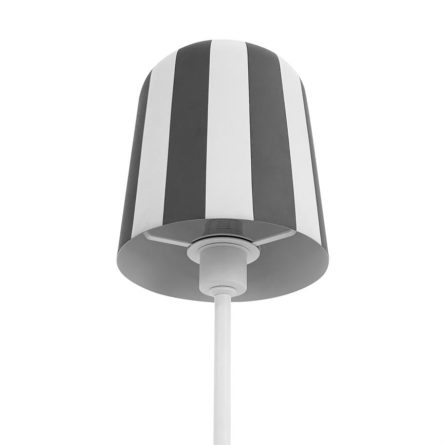 En lampeskærm med lodrette sorte og hvide striber hænger fra en hvid ledning; set nedefra mod en ensartet hvid baggrund i et studieopstillet billede.