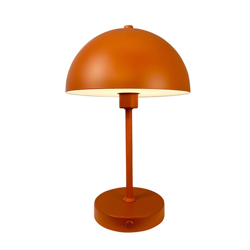 Orange metalbordlampe afgiver blødt, varmt lys fra en halvkugleformet skærm, stående på en slank stang og rund fod mod en ensartet hvid baggrund.