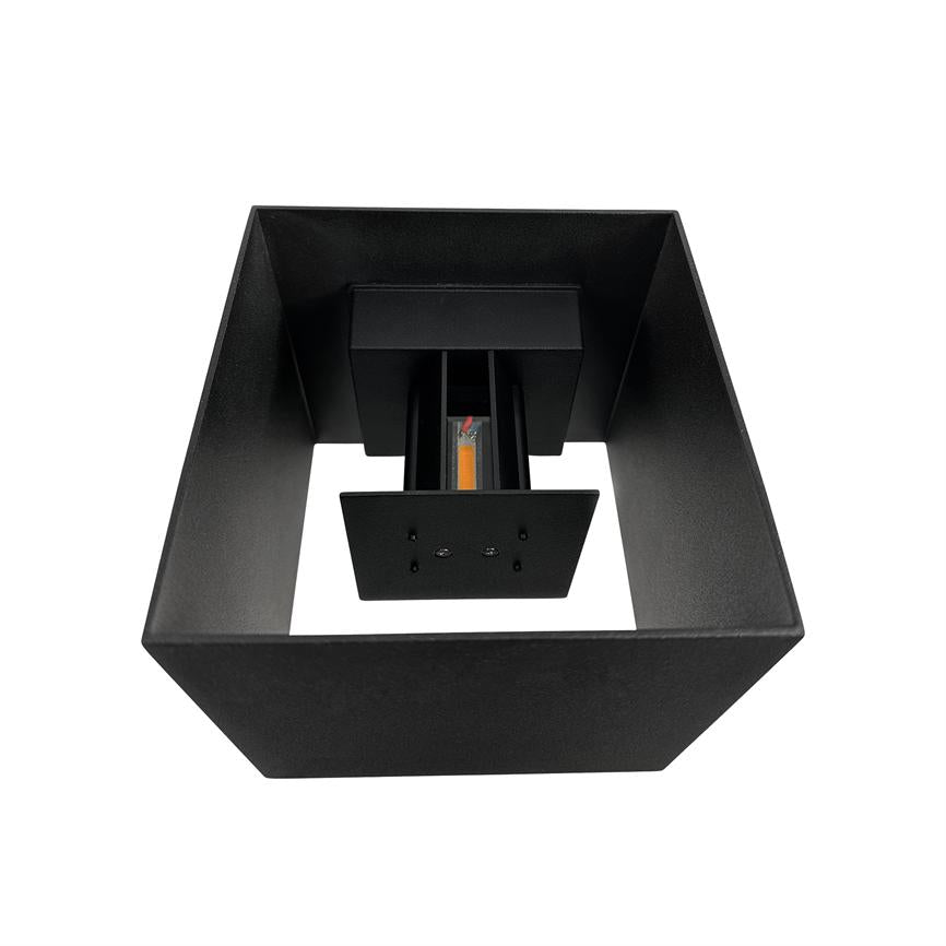 Sort, firkantet lampehylster indeholder et centreret lodret LED-modul med synlig orange filament; lampens indre struktur fremhæves mod en hvid, neutral baggrund.