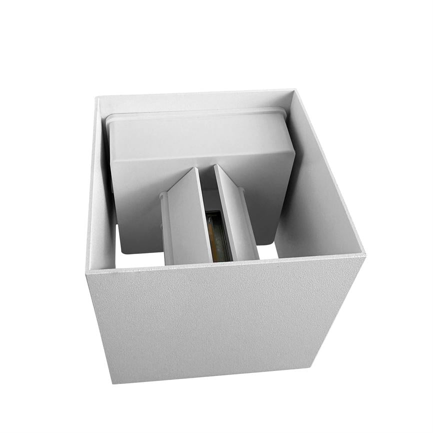 Kubenformet hvid lampe viser et indre modul med to vertikale skærme omkring en synlig lyskilde, fotograferet skråt oppefra mod en neutral hvid baggrund.