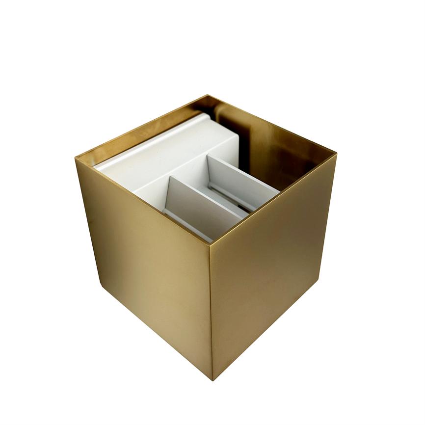 Guld-farvet, kvadratisk beholder rummer hvide indvendige rum og lodrette skillevægge; genstanden står alene på en ensartet, klart hvid baggrund uden andre elementer.