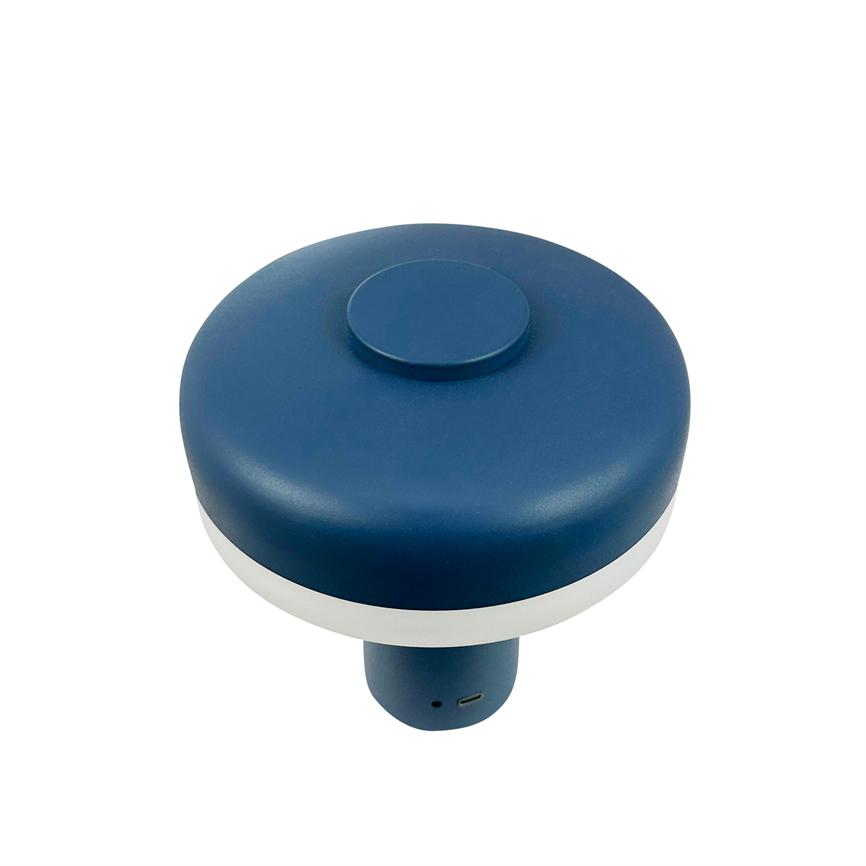 Blå rund enhed med hvid ring hviler på hvid baggrund; toppen har en mindre rund forhøjning, underdelen er cylindrisk og viser en USB-port.