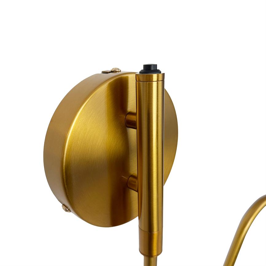 Guldfarvet vægbeslag holder en lodret, børstet cylindrisk lampearm; rund monteringsplade med synlige skruehuller, vist mod en ren, hvid baggrund.