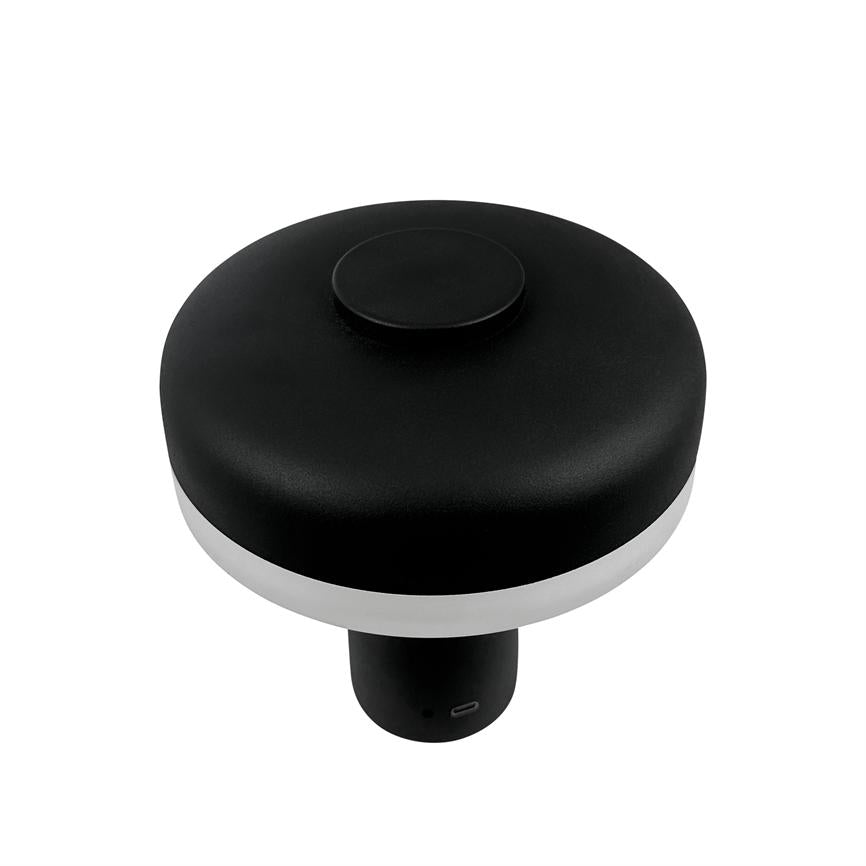 Sort, rund elektronisk enhed med hvidt lysbånd og USB-C-port; står på en kort cylindrisk base, fotograferet isoleret mod hvid baggrund.