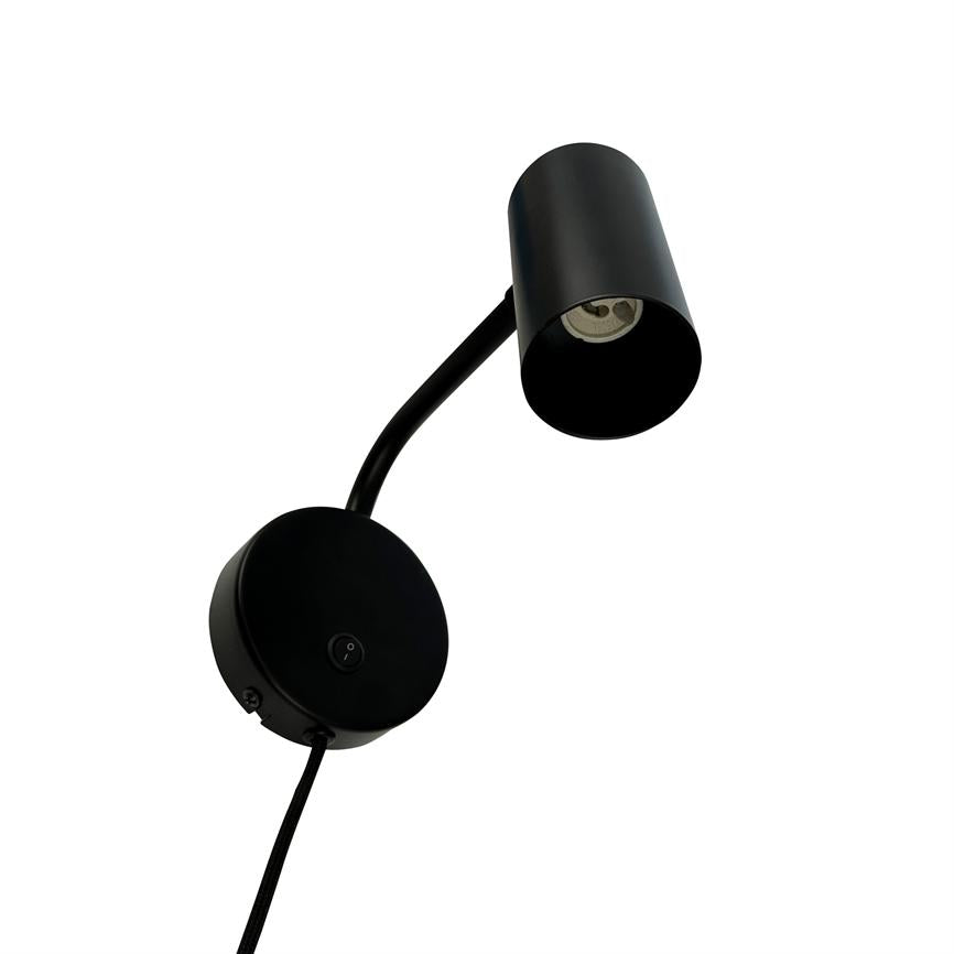 En sort væglampe vipper på en fleksibel arm med cylindrisk lampehoved; rund base med ledning mod hvid baggrund. Knap mærket "I/O".