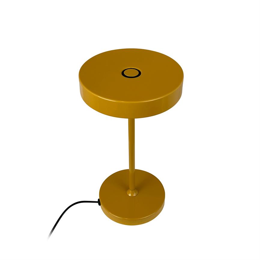 Bordlampe med rund, skiveformet top; en tynd central stang forbinder den til en rund bund, sort strømkabel løber ud fra basen. Objektet står isoleret på hvid baggrund.