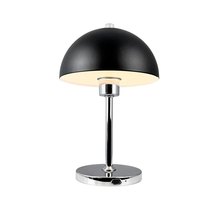 Sort bordlampe med halvkugleformet skærm, udsender varmt lys nedad, monteret på kromstang og rund fod med indbygget USB-port, placeret foran en ensartet hvid baggrund.