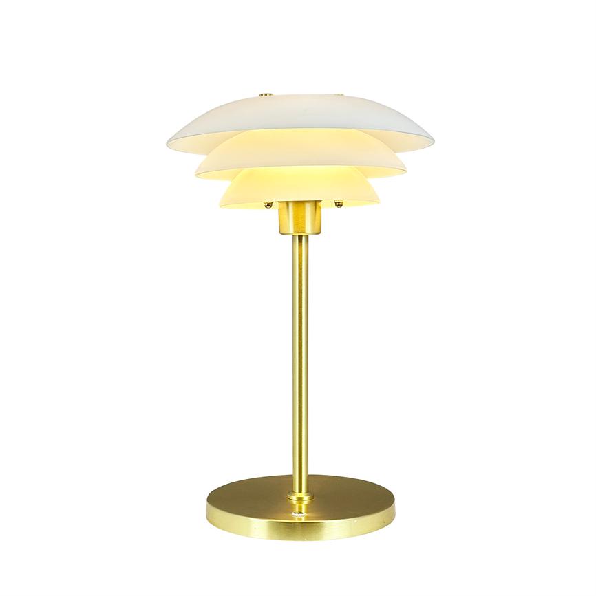 Bordlampe udsender varmt lys, har gyldent stativ og tre lag hvide kupler, placeret isoleret mod en ren hvid baggrund.
