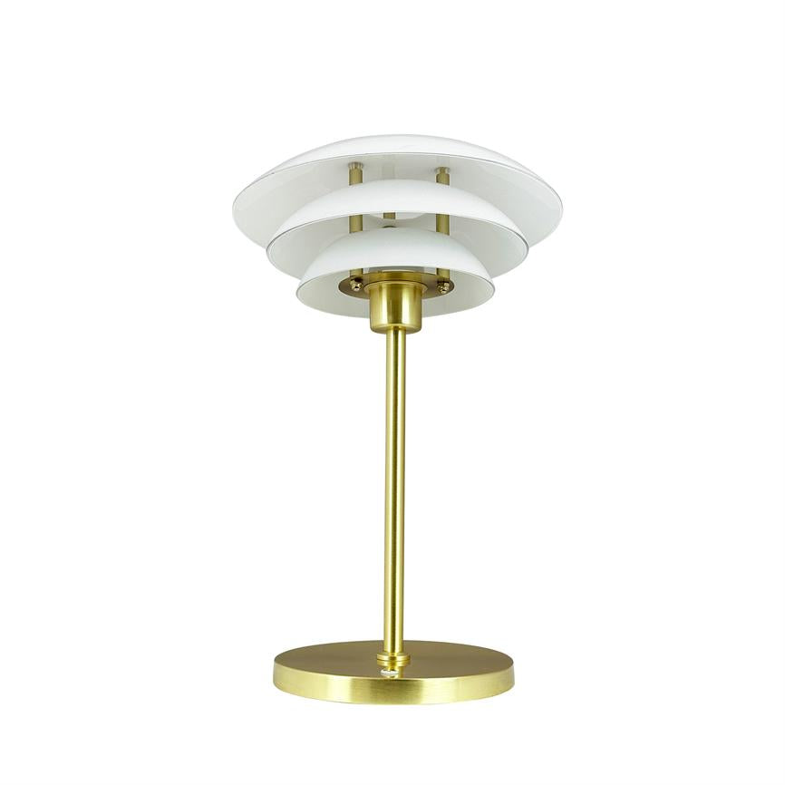 En bordlampe i børstet messing står på en rund fod, har en slank stang og tre lagdelte hvide skærme; placeret foran en neutral hvid studiebaggrund.