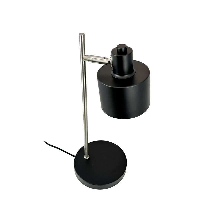 Bordlampe med sort cylindrisk skærm monteret på en kromet lodret stang; skærmen er justerbar via hængsel, og lampen står på rund sort fod mod hvid baggrund.