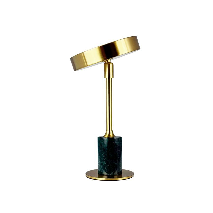 Bordlampe med gylden, skråtstillet cirkulær skærm; slank gylden stang forbinder skærmen til en mørkegrøn marmorsokkel på rund gylden fod. Hvid baggrund.