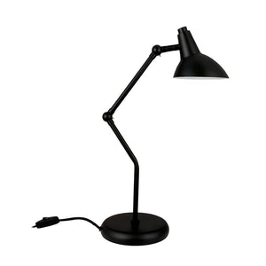 Sort, justerbar skrivebordslampe med to ledede arme og buet skærm; skærmen er vippet nedad, monteret på rund fod med synlig ledning og indbygget afbryder, mod hvid baggrund.