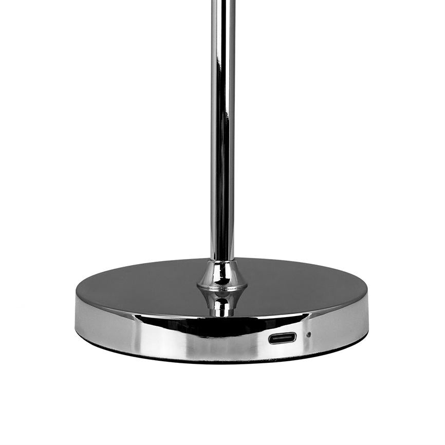 Krom lampefod står oprejst på en flad, rund base mod en hvid baggrund; basens forkant viser en USB-C-port og et lille statuslys.