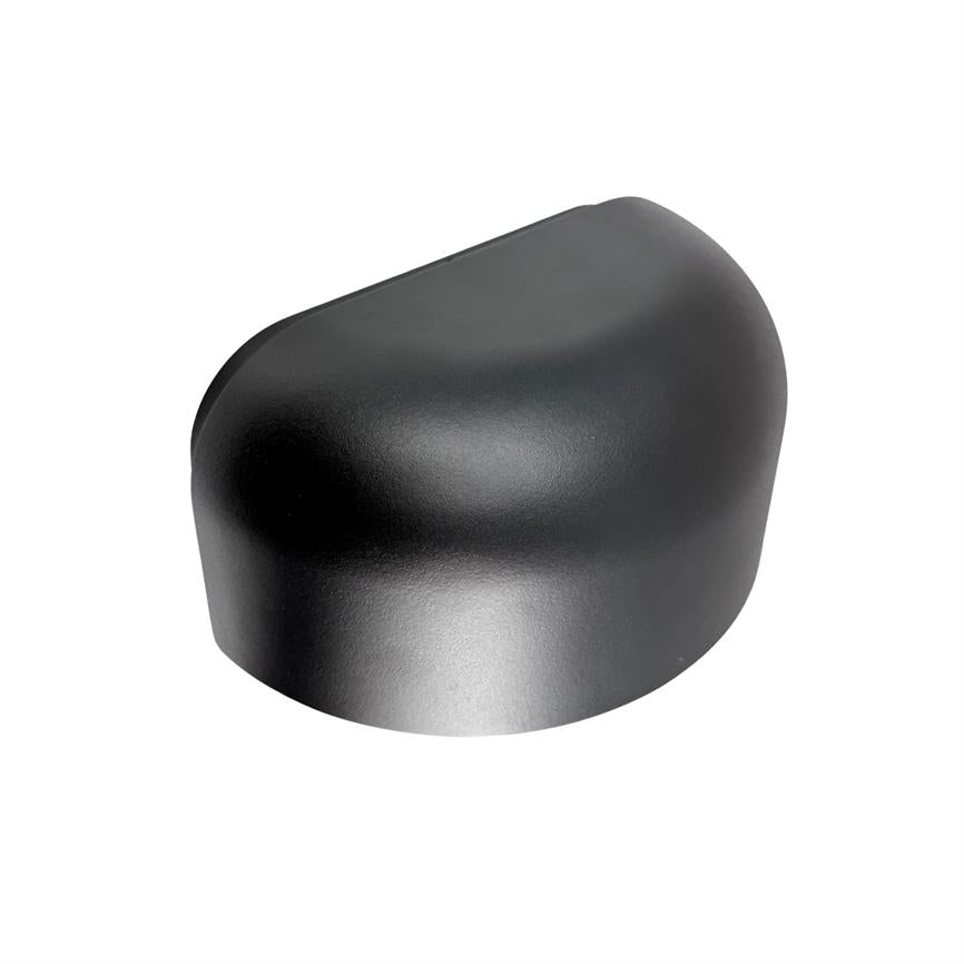 Et mat sort, afrundet plastikdæksel hviler alene; dækslet viser bløde kurver og glat overflade, placeret mod en neutral hvid baggrund med diskret skygge.