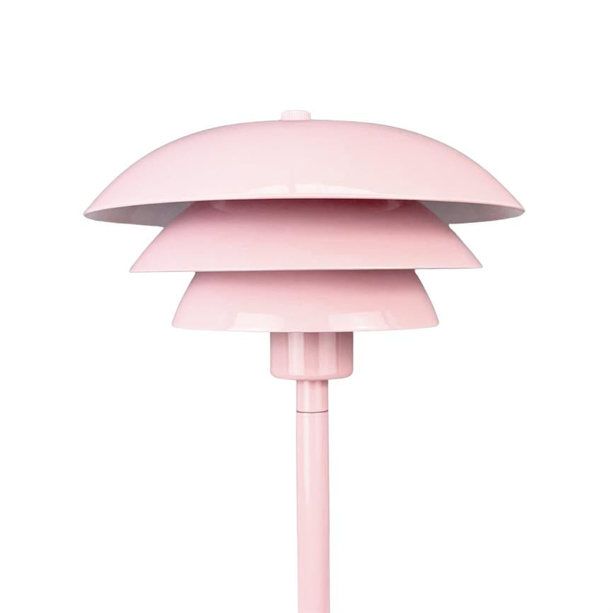 Lyserød lampe med tre lagede, skålformede skærme monteret på en slank stang mod en ensartet hvid baggrund.